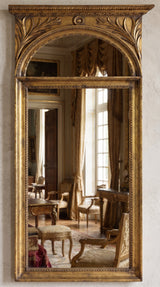 Hand-carved gilded Venetian mirror with scrolled frame, styled in an entryway setting.
